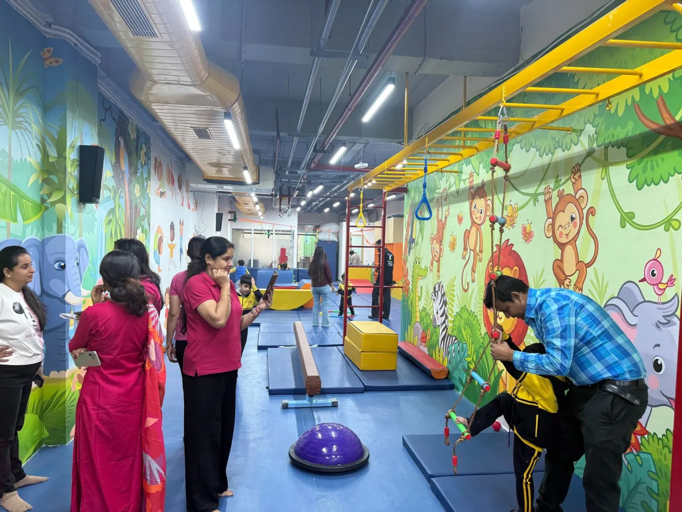 Children practising on the balance beam with coach support