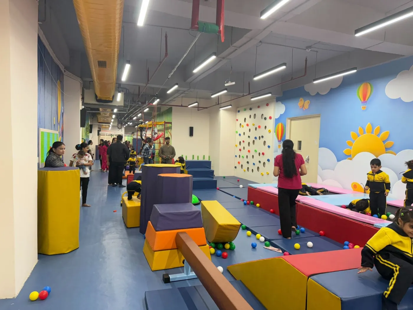 The main training floor of a kids' gym with climbing wall and balance beam