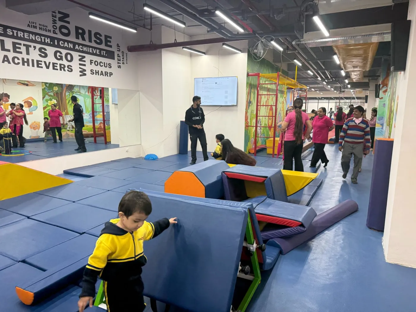 A child climbing over soft-play blocks during an activity session