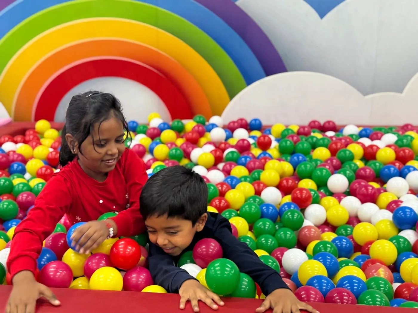 Young children playing on soft-play equipment at a kids' gym